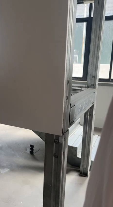 Perfil estructural de acero de un panel de cerramiento junto a los ventanales de la nave