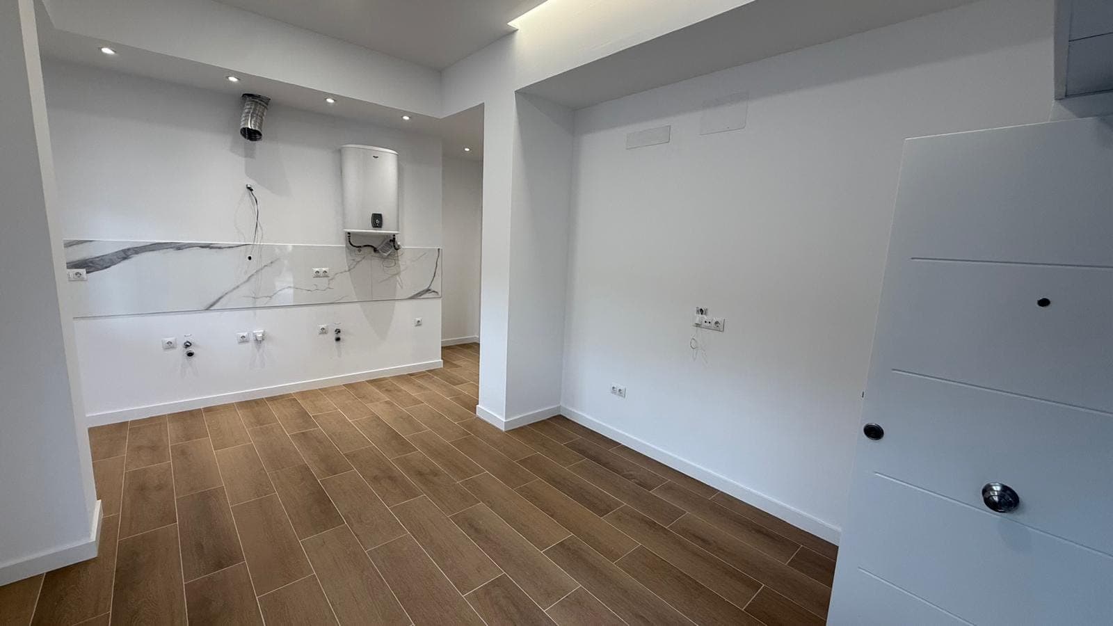 Salón-comedor-cocina terminado de una de las viviendas de la operación Amate, en Sevilla